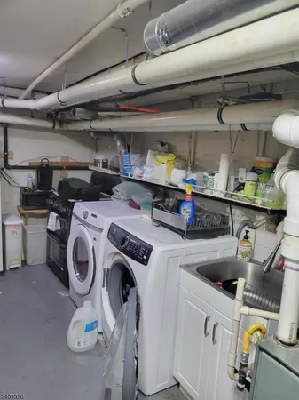 a utility room with dryer washer and stair
