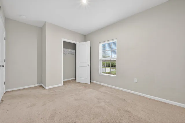 an empty room with windows and closet