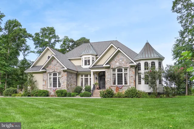 a front view of a house with a garden and trees
