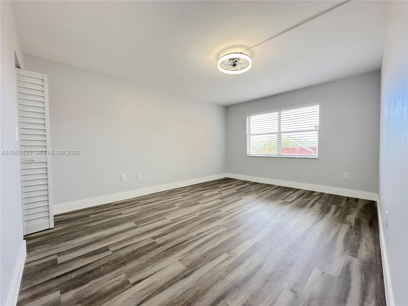 3110 North Pine Island Road, Unit 408 Sunrise, FL 33351 - Photo 9 of 18 an empty room with wooden floor and windows