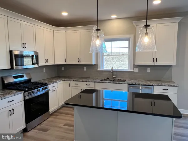 a kitchen with a stove sink and cabinets