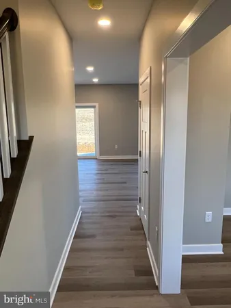 an empty room with wooden floor a fireplace and windows