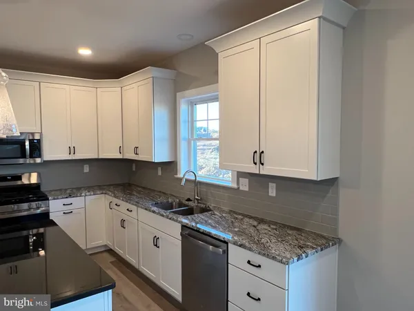 a kitchen with stainless steel appliances granite countertop a sink a stove and a refrigerator