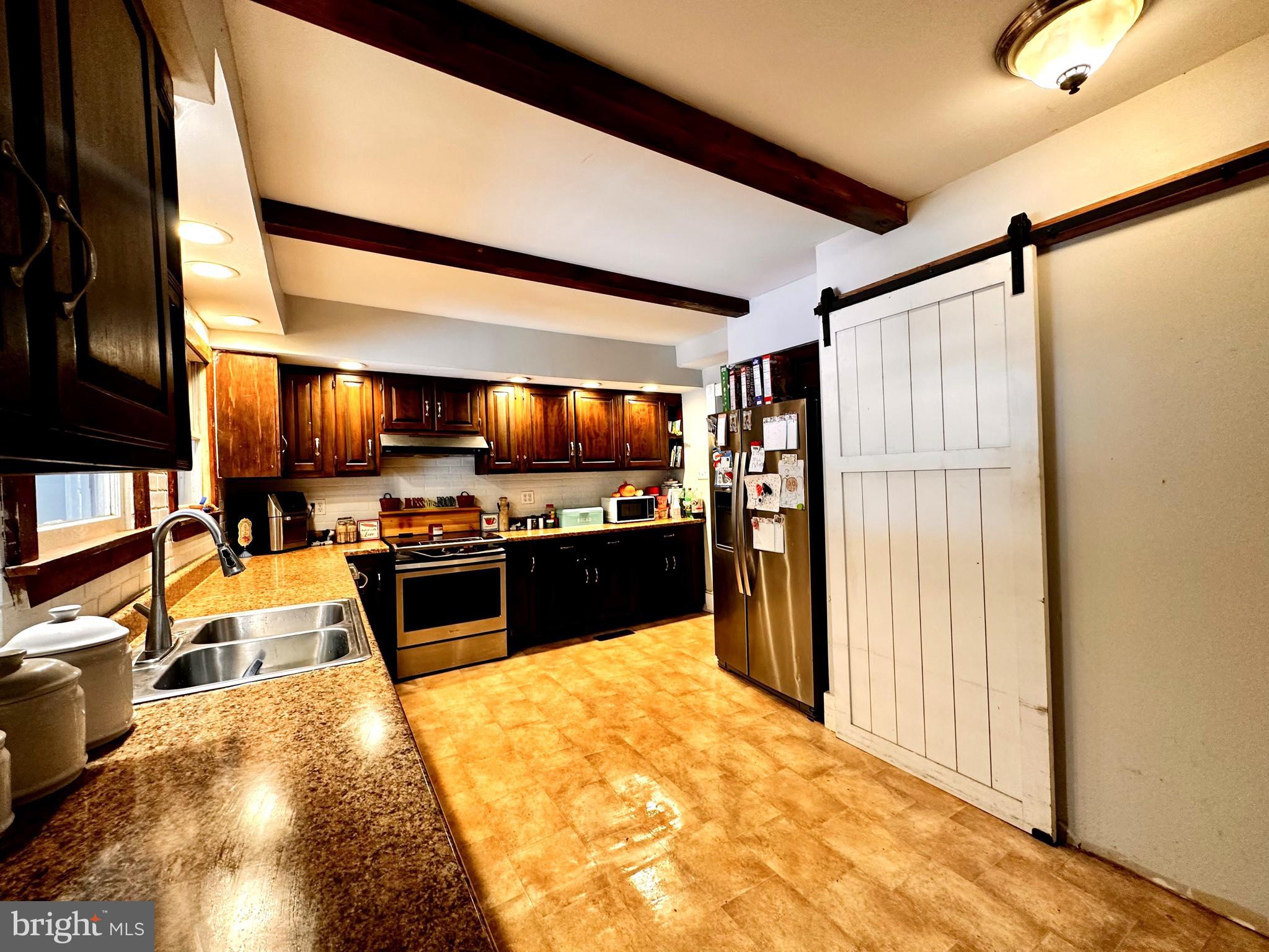 210 Old Line Road Goldsboro, MD 21636 - Photo 13 of 27 a kitchen with stainless steel appliances kitchen island granite countertop a refrigerator and a stove top oven