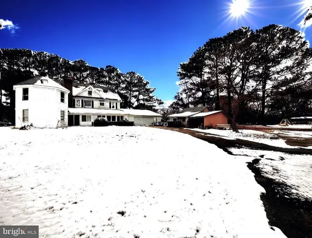 a view of residential houses with snow on the road