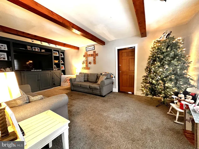 a living room with furniture a flat screen tv and a floor to ceiling window