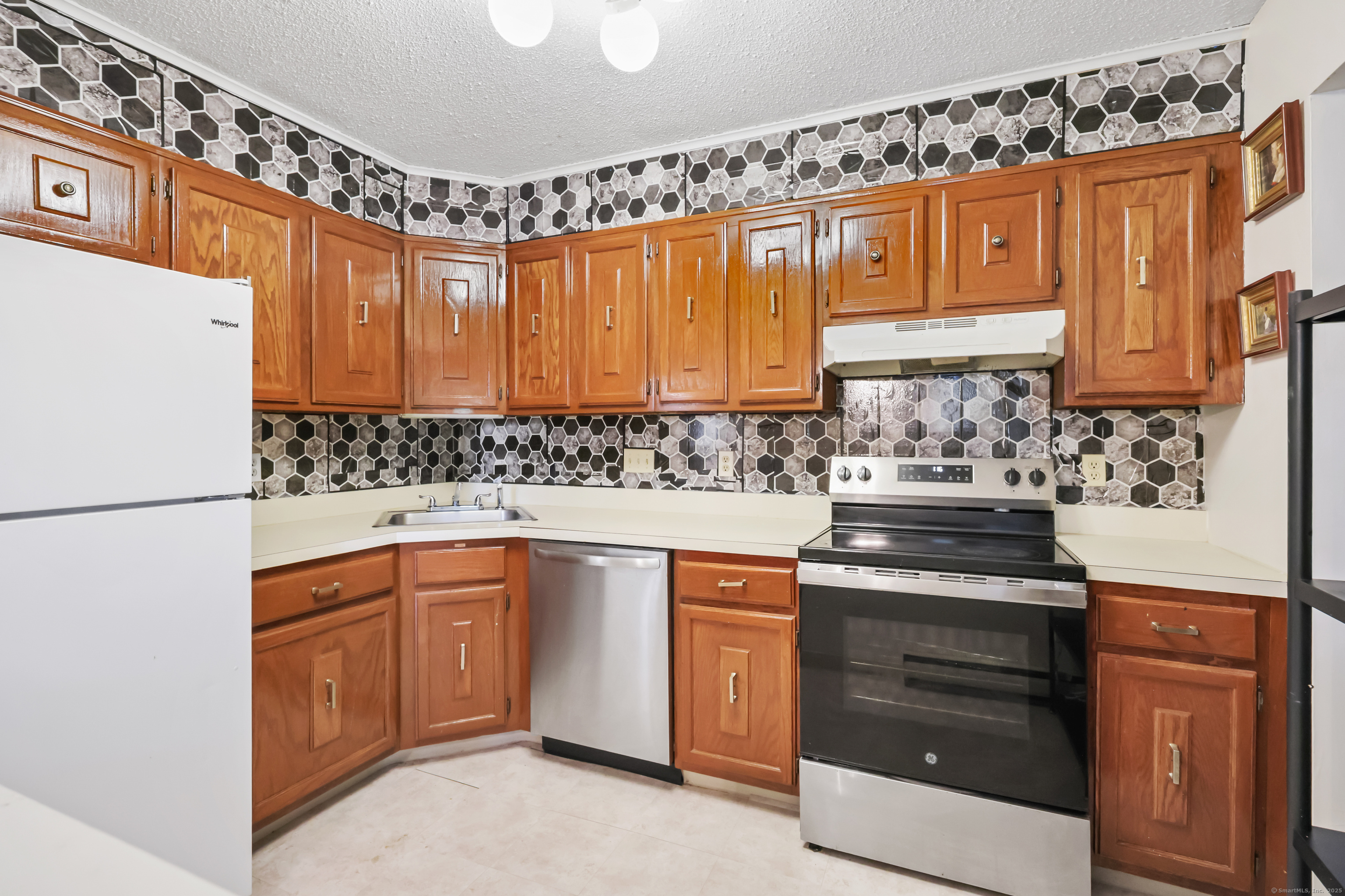 187 Flax Hill Road, Unit D5 Norwalk, CT 06854 - Photo 8 of 19 a kitchen with stainless steel appliances granite countertop a stove a sink and a refrigerator