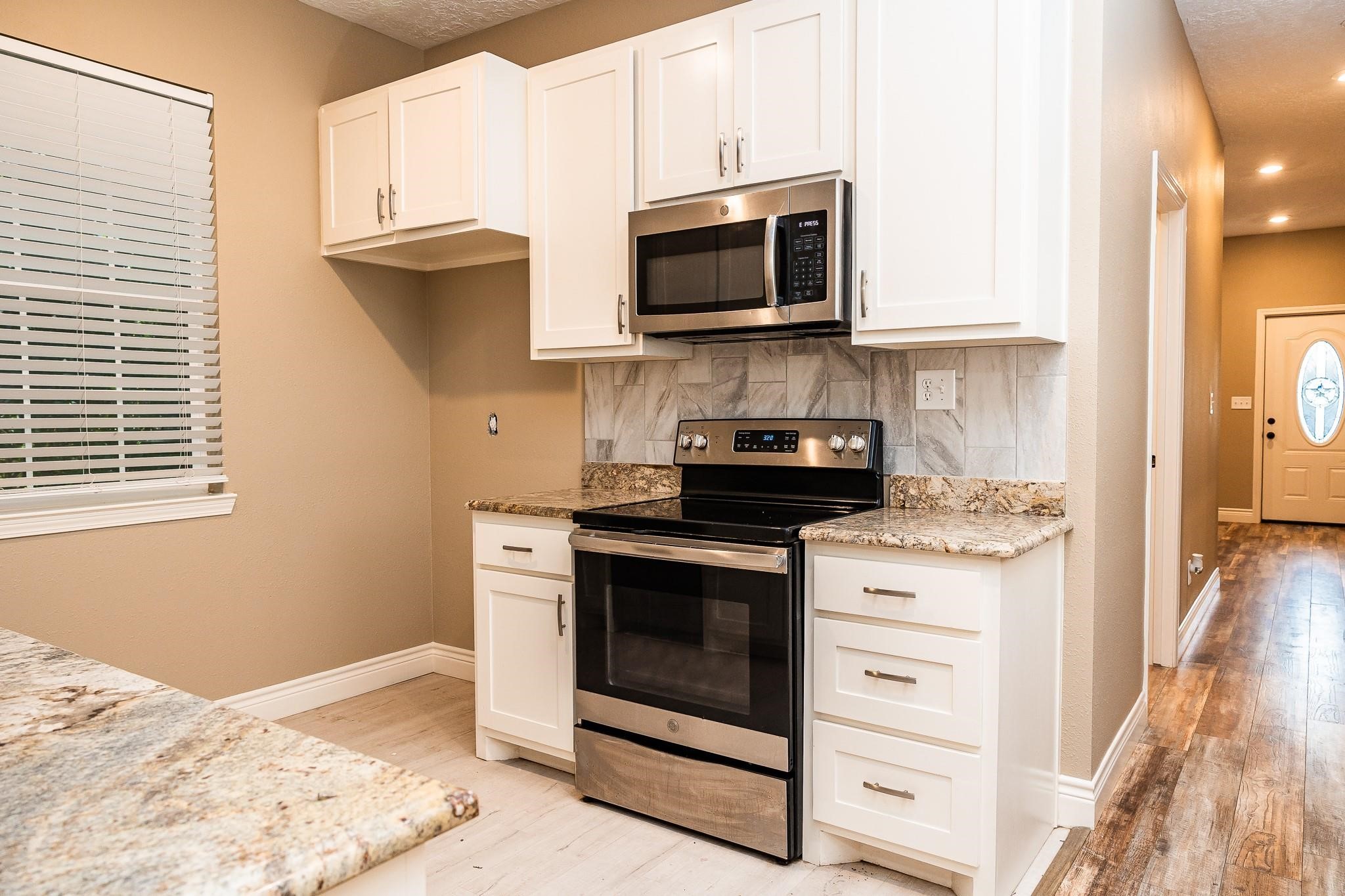 1306 South Austin Street Brenham, TX 77833 - Photo 13 of 16 a kitchen with a stove and a microwave