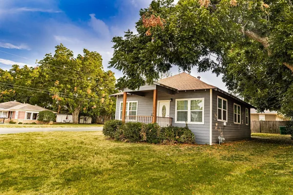 a front view of a house with a yard and trees
