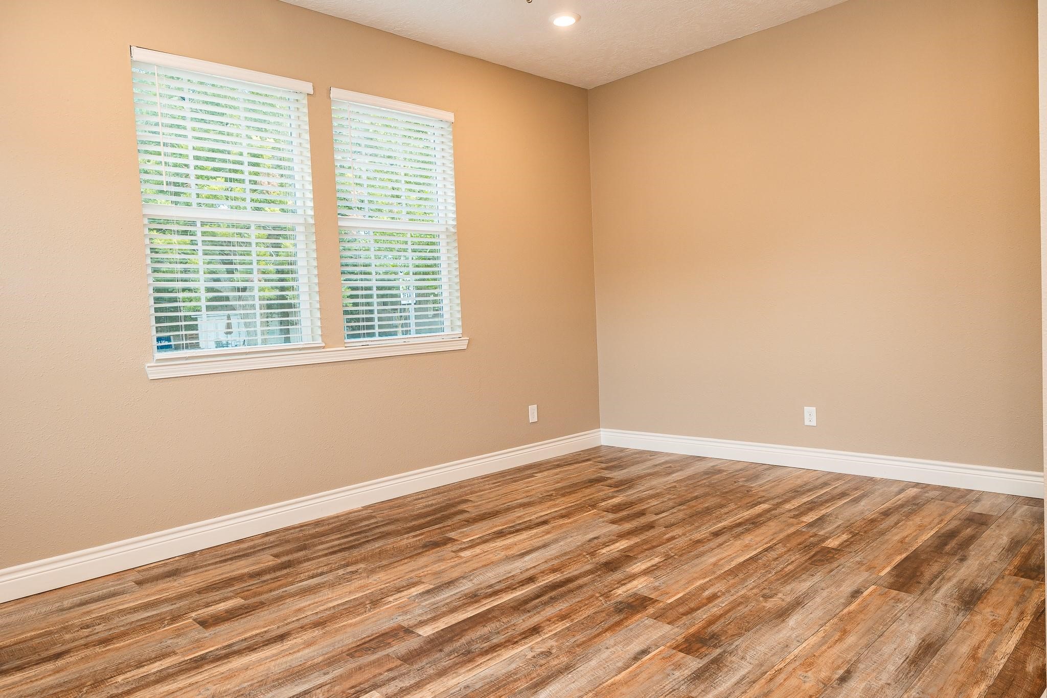 1306 South Austin Street Brenham, TX 77833 - Photo 6 of 16 a view of an empty room with wooden floor and a window