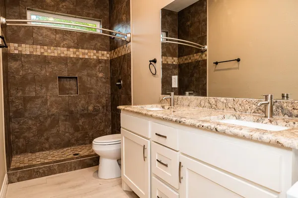 a bathroom with a granite countertop sink toilet and shower