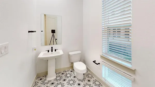 a bathroom with a sink a toilet and a mirror