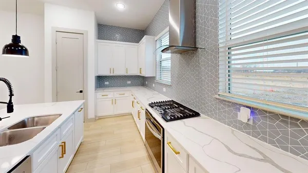 a kitchen with granite countertop a sink a stove and cabinets
