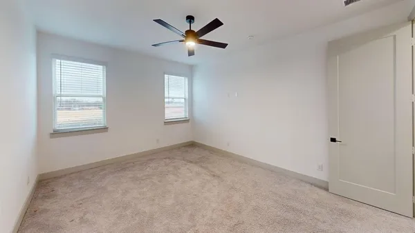 an empty room with a window and a fan