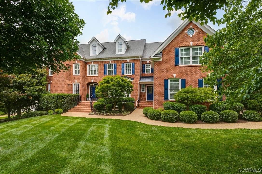 a front view of a house with a yard and plants