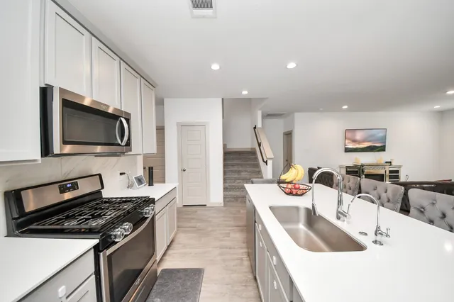 a kitchen that has a sink and a stove top oven