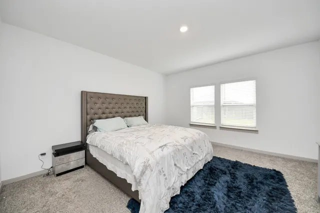 a bed sitting in a bedroom next to a window