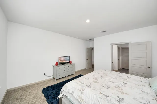 a bedroom with a bed and a dresser