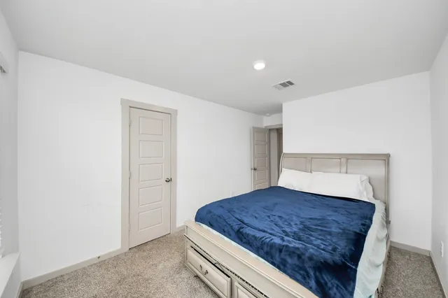 a living room with a bed and a night stand