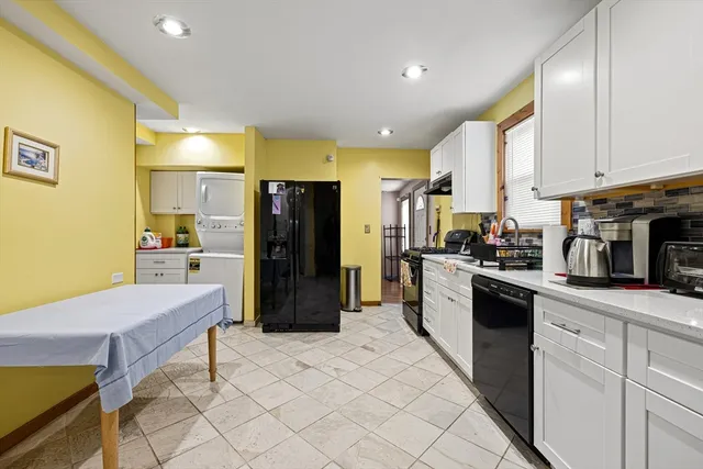 a kitchen with stainless steel appliances kitchen island granite countertop a refrigerator a stove a sink dishwasher and white cabinets with wooden floor