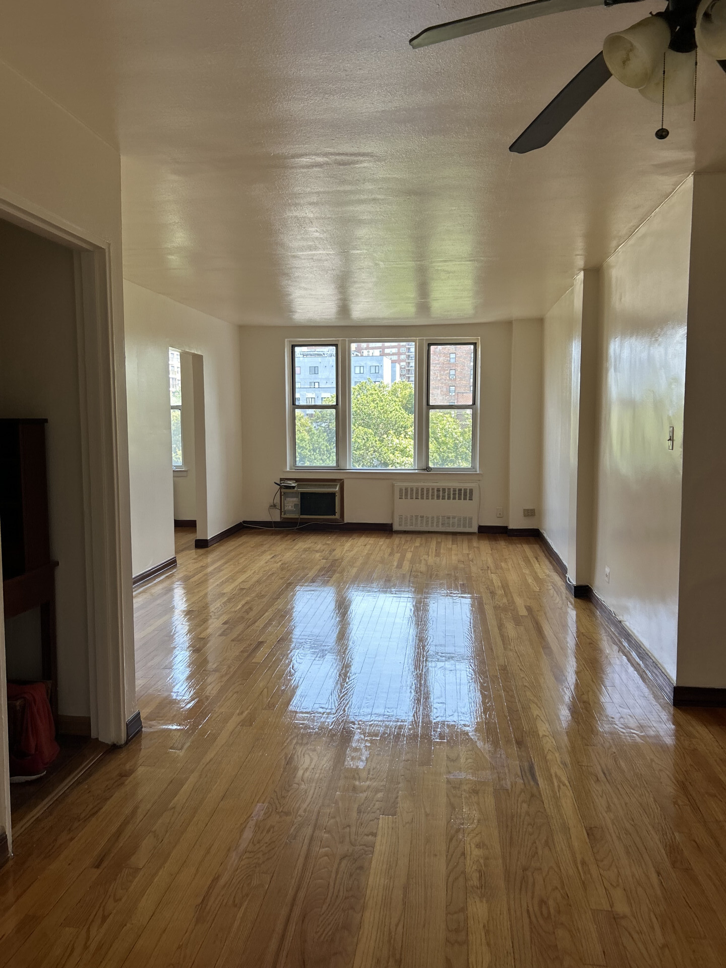 2385 Barker Avenue, Unit 5L Bronx, NY 10467 - Photo 1 of 15 a view of an empty room with wooden floor and a window