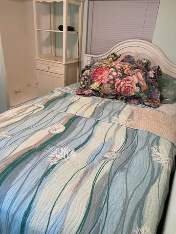 a bedroom with a bed and a painting on the wall