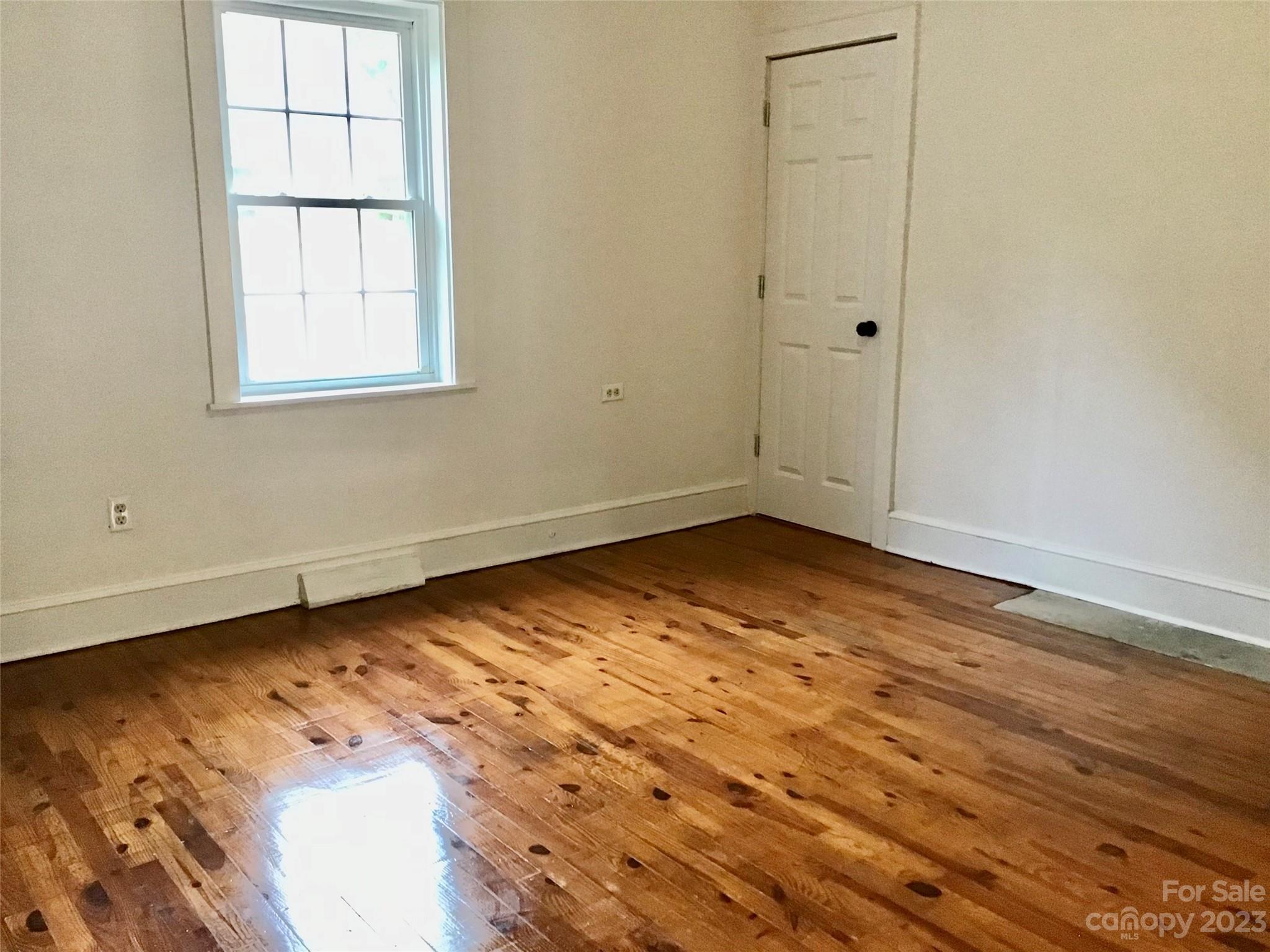 101 Alexander Road Stony Point, NC 28678 - Photo 9 of 15 an empty room with wooden floor and windows