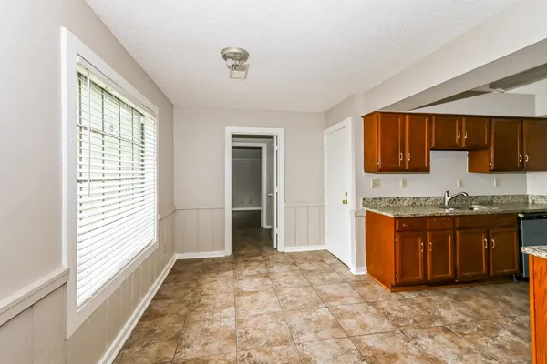a large kitchen with kitchen island granite countertop a sink and a stove top oven