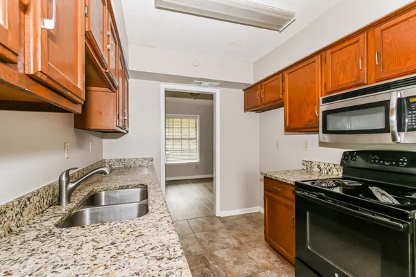 a kitchen with granite countertop a sink and a stove top oven