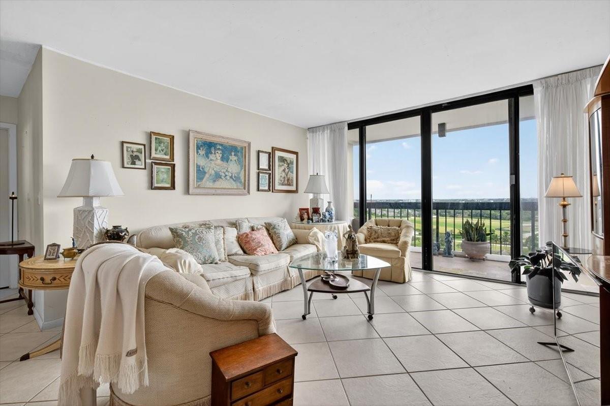a living room with furniture and floor to ceiling window