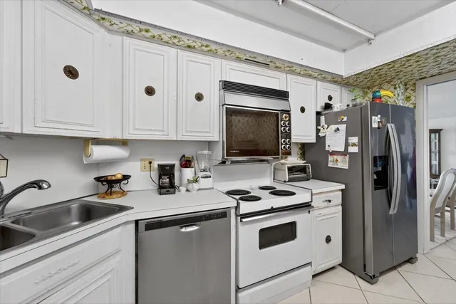 a kitchen with stainless steel appliances a stove a sink a refrigerator and cabinets