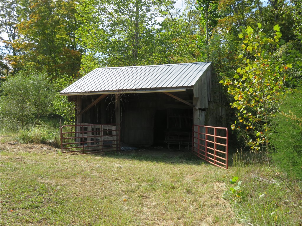 748 Inlow Avenue Peebles, OH 45660 - Photo 42 of 61 This rustic barn offers practical storage amidst a natural, green setting.