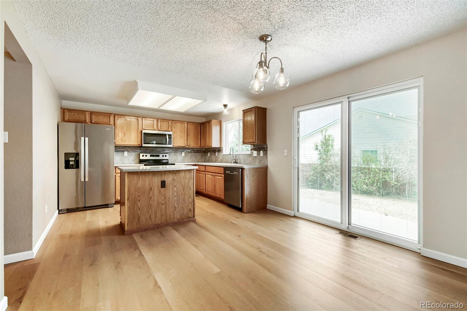 13400 Raritan Street Denver, CO 80234 - Photo 15 of 32 a large kitchen with kitchen island a large counter space a sink appliances and cabinets