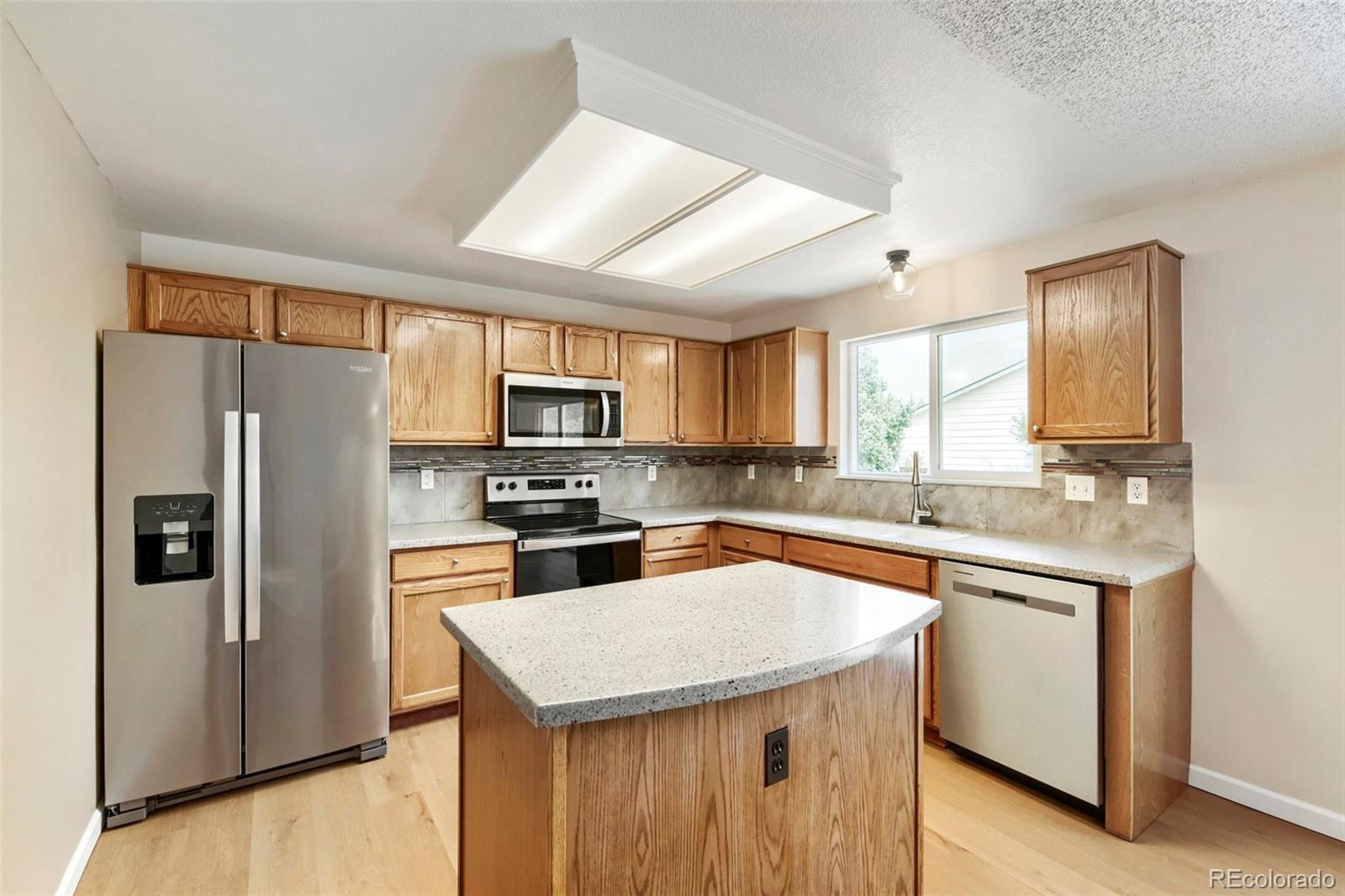 13400 Raritan Street Denver, CO 80234 - Photo 16 of 32 a kitchen with stainless steel appliances a refrigerator stove microwave and sink