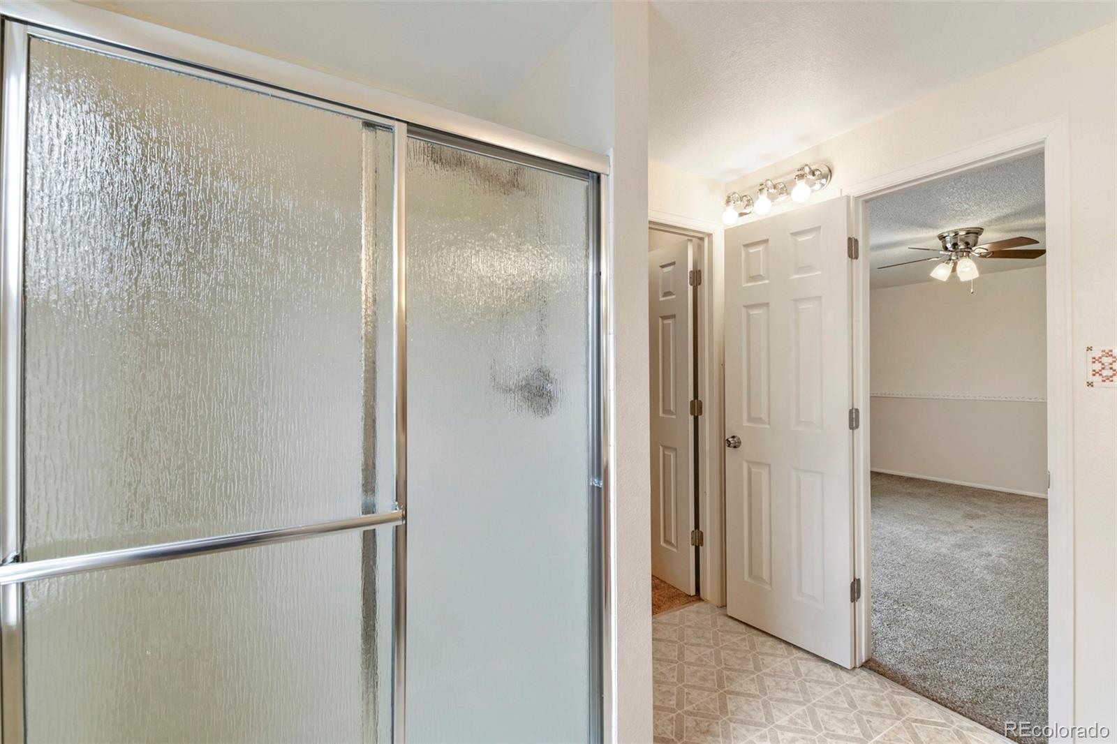 13400 Raritan Street Denver, CO 80234 - Photo 24 of 32 a bathroom with a glass shower door
