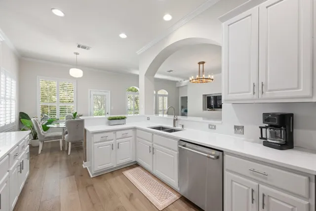 a kitchen with sink white cabinets and stove