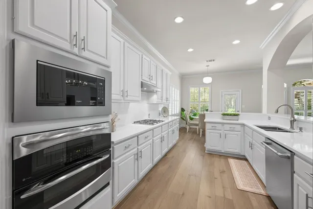 a kitchen with stainless steel appliances kitchen island granite countertop a stove top oven and sink