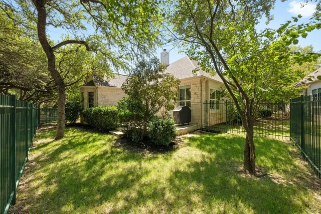 a yellow house with tree in front of it