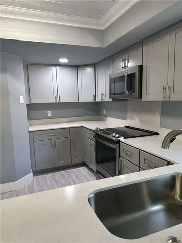 a kitchen with stainless steel appliances granite countertop a sink a stove and a microwave