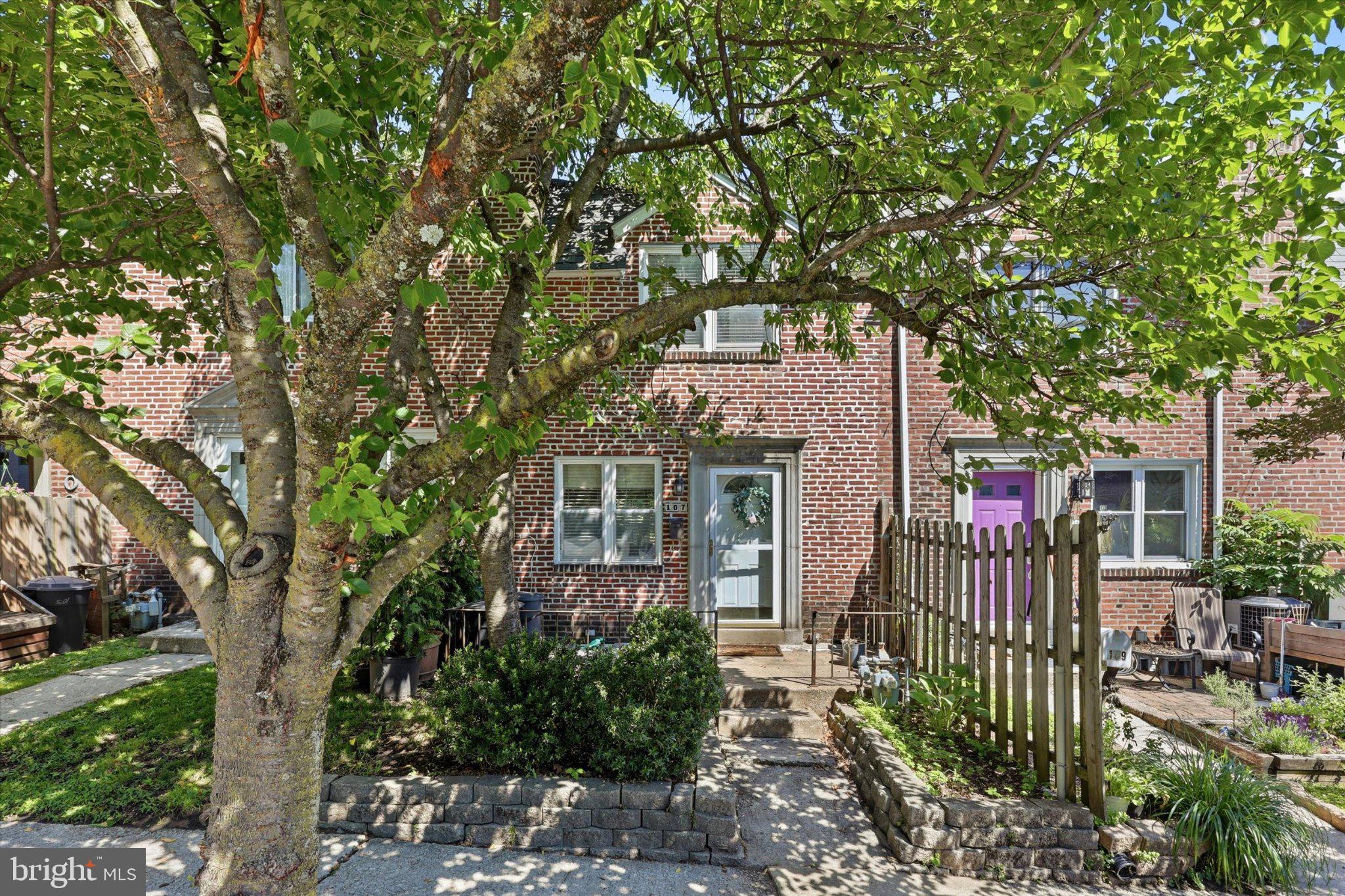Charming brick home with lush greenery.
