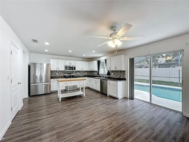 a kitchen with a refrigerator and white cabinets