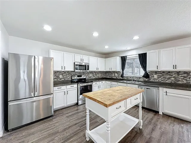 a kitchen with a refrigerator a sink and wooden cabinets