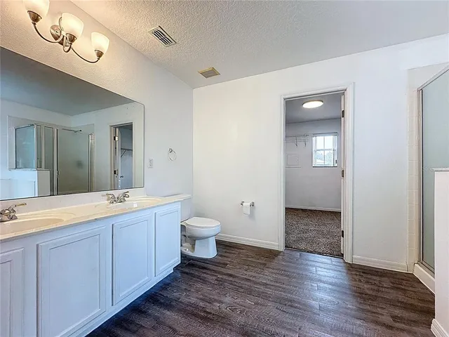 a spacious bathroom with a granite countertop sink mirror and toilet