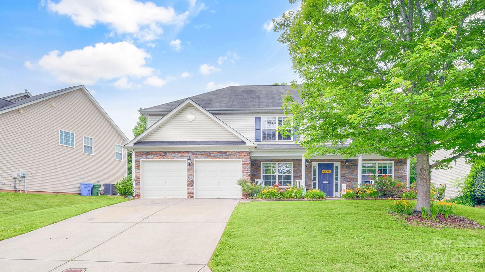 a front view of a house with a garden and yard