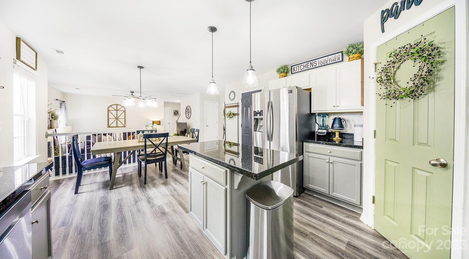 5207 Sunriver Road Gastonia, NC 28054 - Photo 13 of 46 a open kitchen with stainless steel appliances granite countertop a refrigerator a oven a stove and a dining table with wooden floor