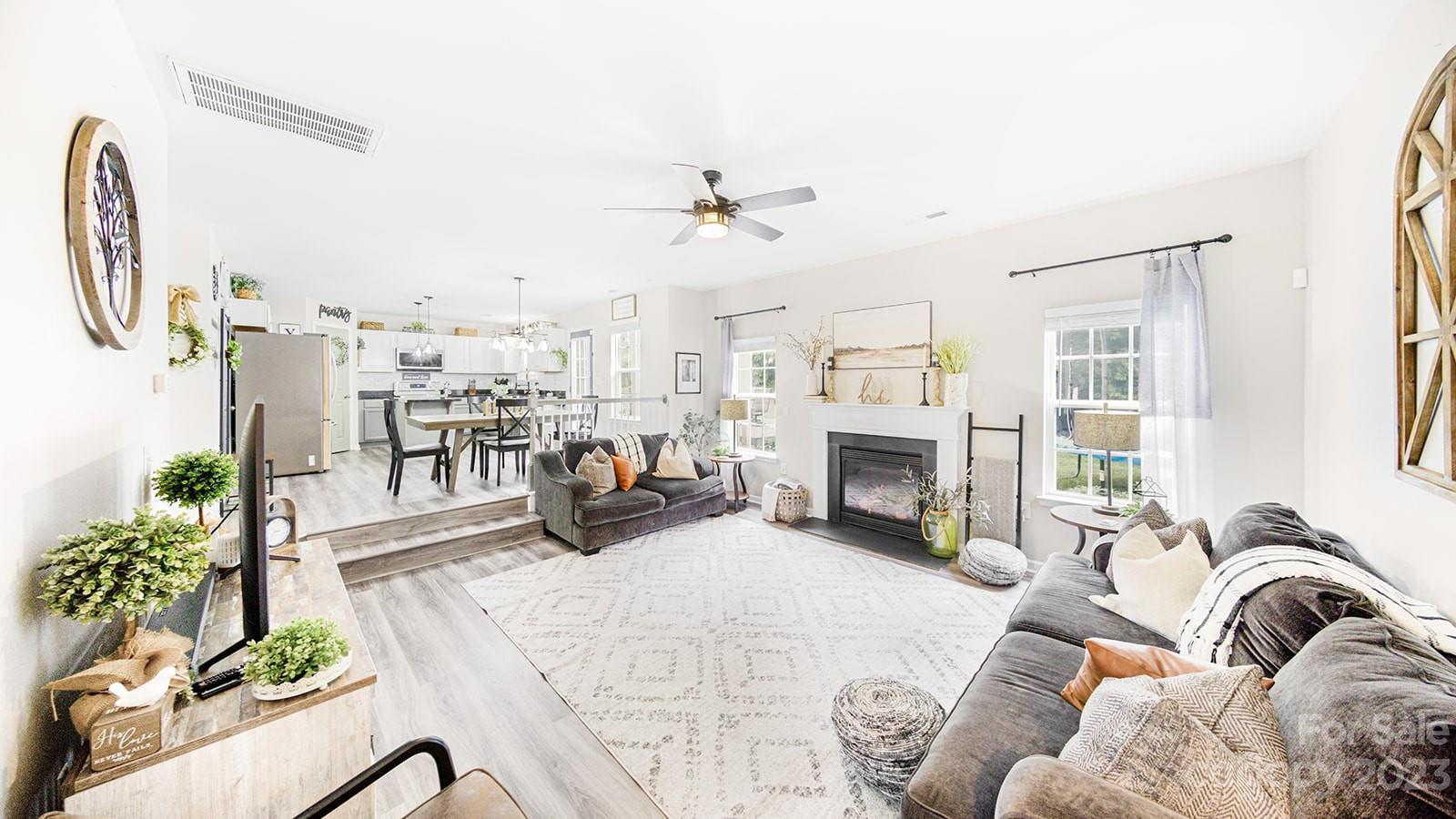 5207 Sunriver Road Gastonia, NC 28054 - Photo 15 of 46 a living room with furniture a fireplace and a chandelier