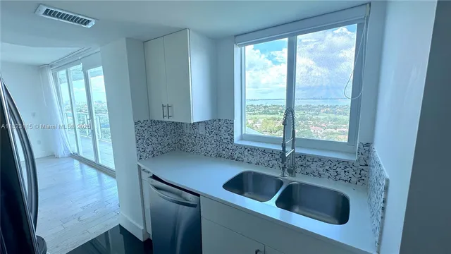 a kitchen with a sink and large window