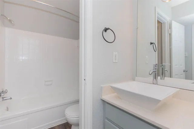 a kitchen with stainless steel appliances granite countertop a sink stove and white cabinets with wooden floor