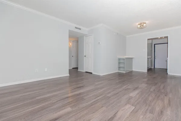 a view of empty room with wooden floor