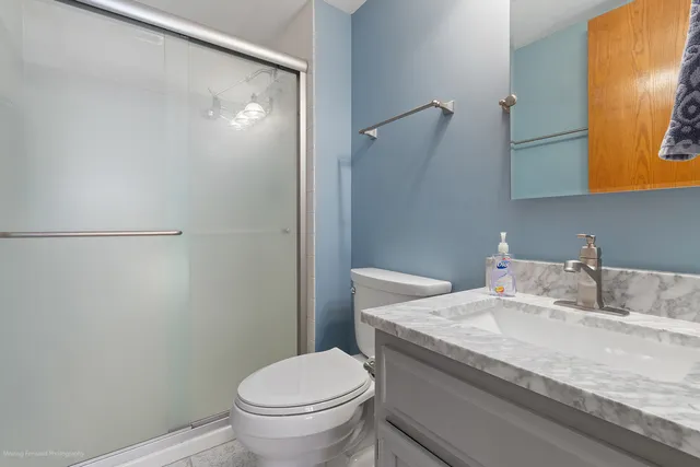 a bathroom with a granite countertop sink toilet and a mirror